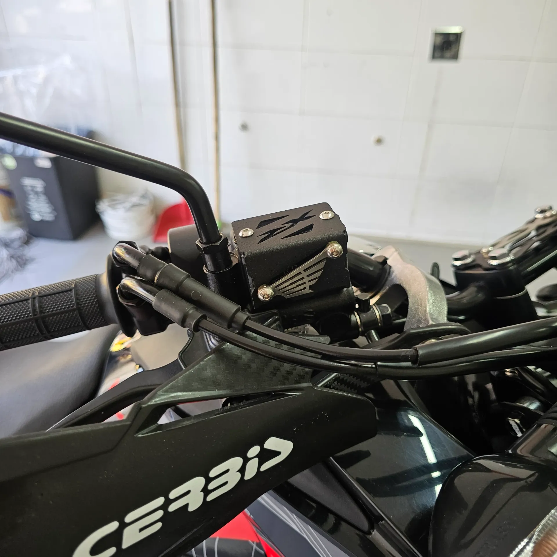 [1833] PROTECTOR DE BOMBA FRENO DELANTERO HONDA XRE (ACERO) (Negro)